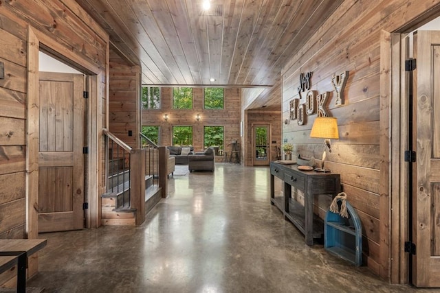 corridor with wooden walls, concrete floors, and wood ceiling