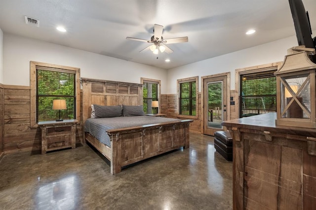 bedroom with access to exterior, ceiling fan, and wood walls