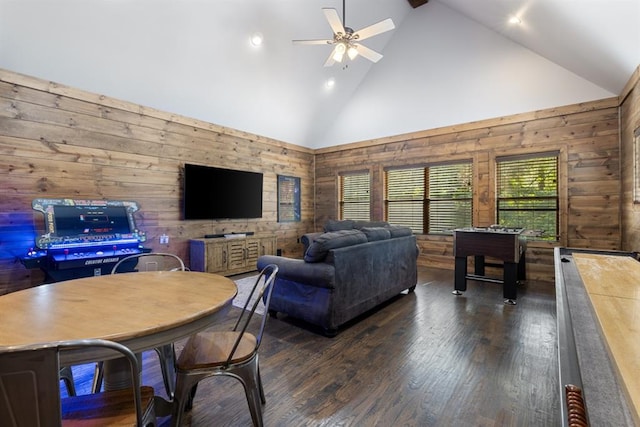 living room with dark hardwood / wood-style flooring, high vaulted ceiling, ceiling fan, and wooden walls