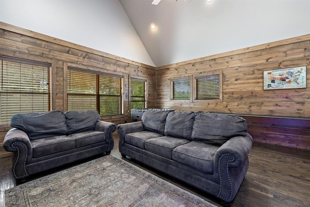 living room featuring a wealth of natural light, dark hardwood / wood-style flooring, high vaulted ceiling, and wood walls