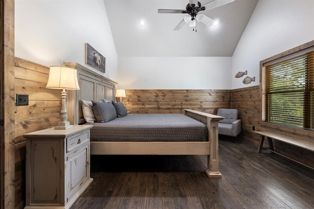 bedroom with high vaulted ceiling, ceiling fan, dark hardwood / wood-style flooring, and wooden walls