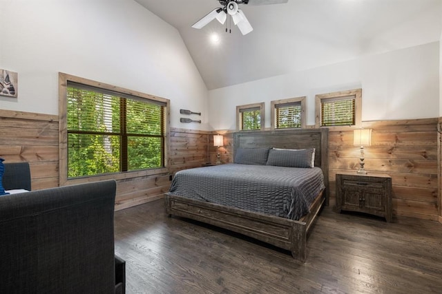 bedroom with dark wood-type flooring, high vaulted ceiling, ceiling fan, and wooden walls