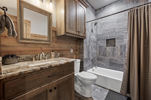 full bathroom featuring wood walls, shower / tub combo with curtain, vanity, and toilet