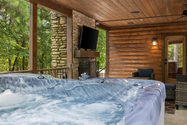 bedroom with wood ceiling and an outdoor stone fireplace