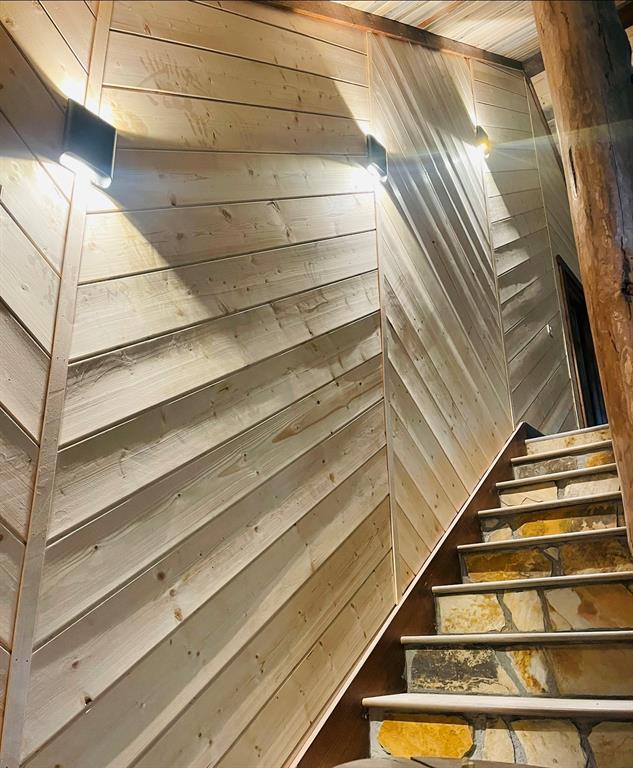 staircase featuring wooden walls