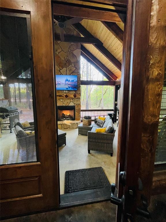 interior space featuring vaulted ceiling with beams, wood ceiling, and a fireplace