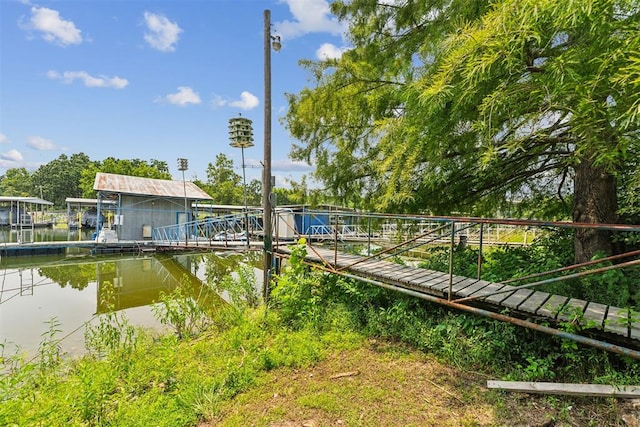 view of community with a water view and a boat dock