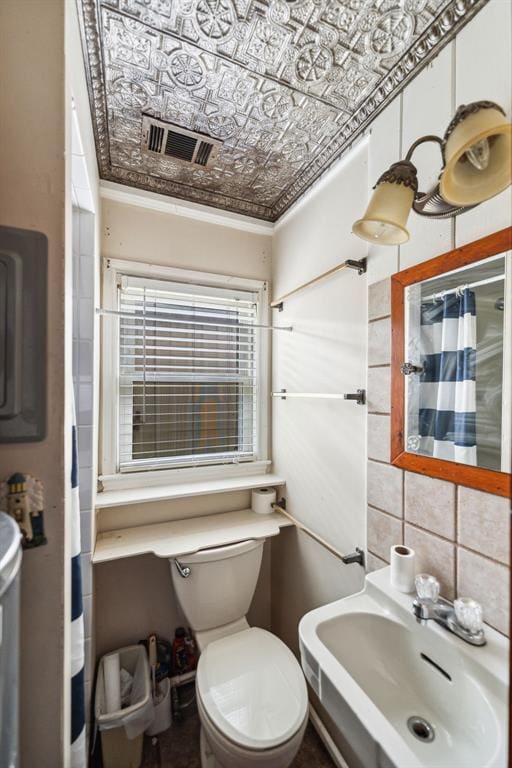 bathroom featuring backsplash, sink, a shower with shower curtain, and toilet