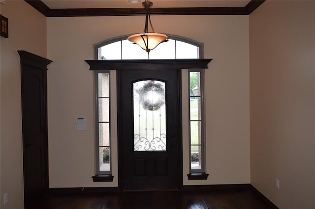 entryway with ornamental molding, dark wood-type flooring, and a healthy amount of sunlight