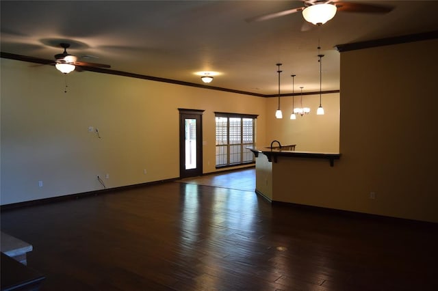 spare room featuring ceiling fan with notable chandelier, dark hardwood / wood-style flooring, and crown molding