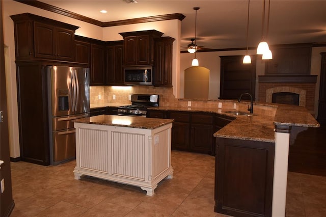 kitchen featuring appliances with stainless steel finishes, dark brown cabinets, ceiling fan, decorative light fixtures, and a kitchen island