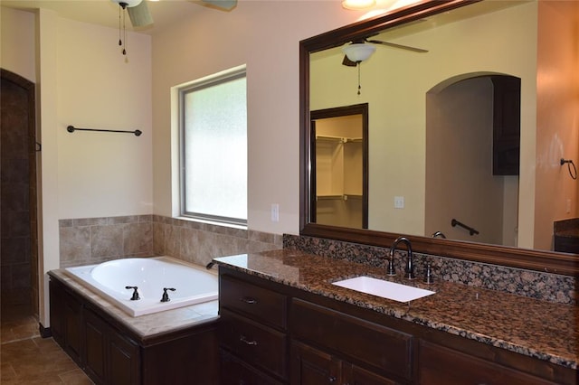 bathroom with ceiling fan, plenty of natural light, a bathtub, and vanity