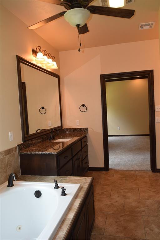 bathroom featuring vanity and tiled tub