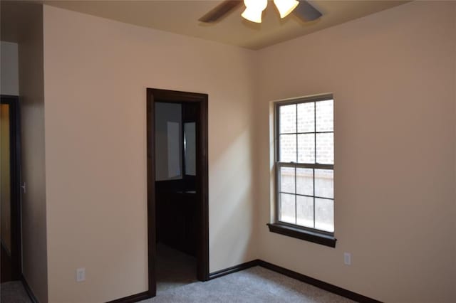 carpeted spare room with ceiling fan