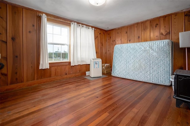 unfurnished bedroom featuring wooden walls and hardwood / wood-style flooring