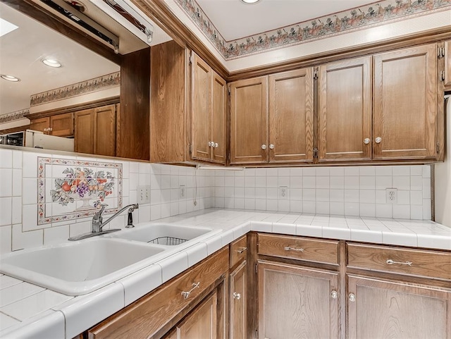 kitchen with tasteful backsplash, tile countertops, and sink