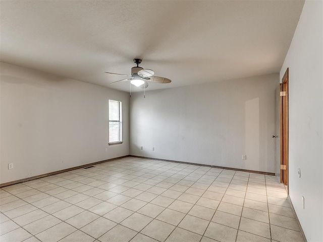 tiled spare room with ceiling fan