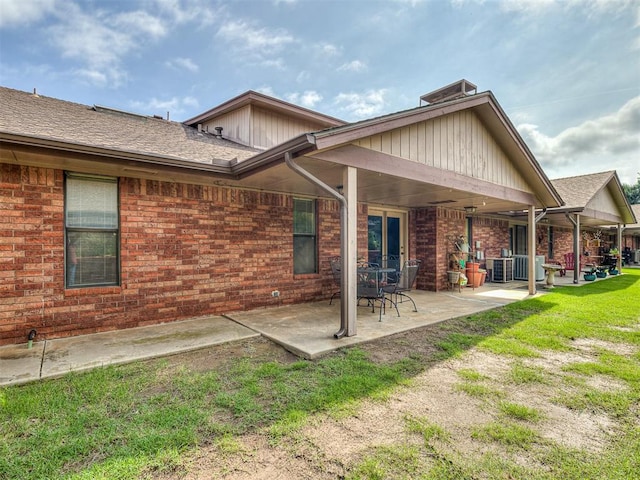 back of house featuring a lawn, a patio, and central AC