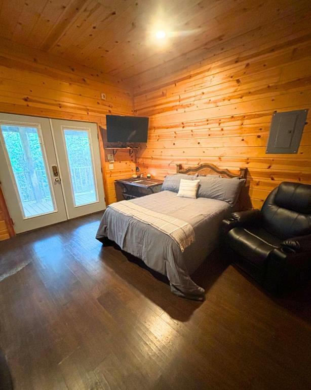 988 Ridge Point Rd, Fort Towson, OK 74735 - bedroom with access to exterior, wood finished floors, electric panel, wooden walls, and wooden ceiling