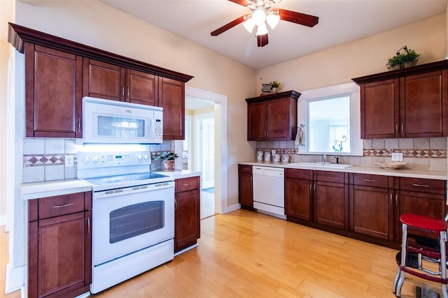 kitchen featuring white appliances, sink, decorative backsplash, ceiling fan, and light hardwood / wood-style floors