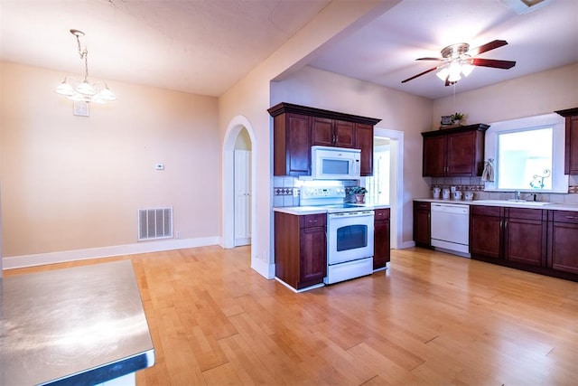 kitchen featuring backsplash, hanging light fixtures, white appliances, and light wood-type flooring