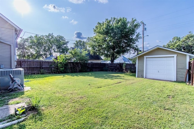 view of yard with an outdoor structure, central AC, and a garage