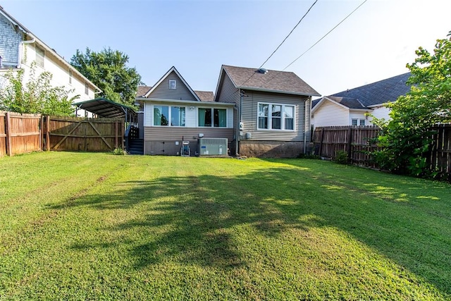 rear view of house with central air condition unit and a yard