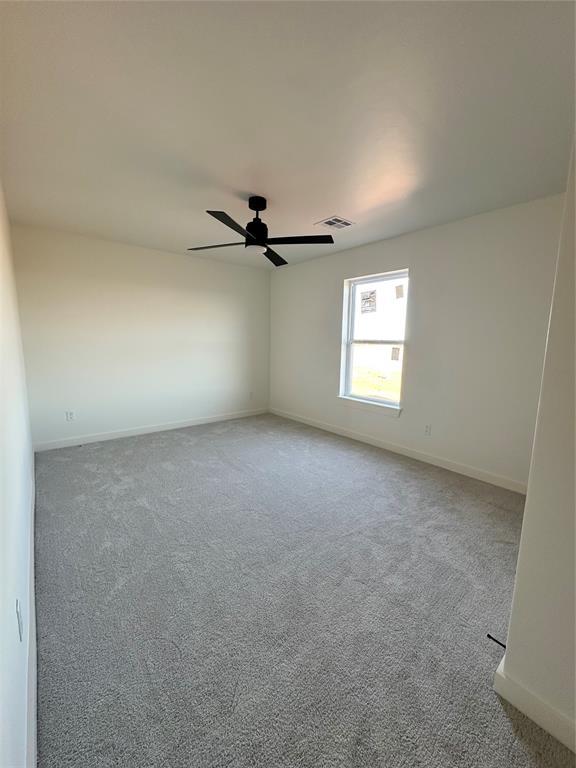 carpeted empty room featuring ceiling fan