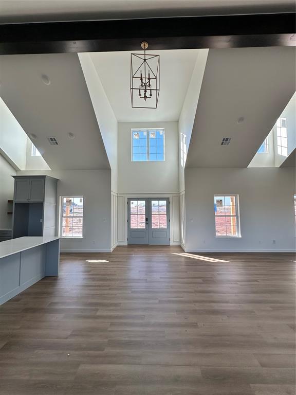 unfurnished living room featuring hardwood / wood-style floors, french doors, and a healthy amount of sunlight