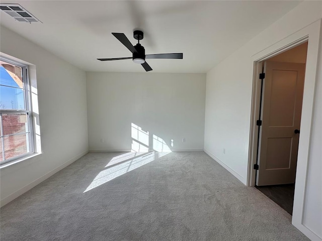 carpeted spare room featuring ceiling fan