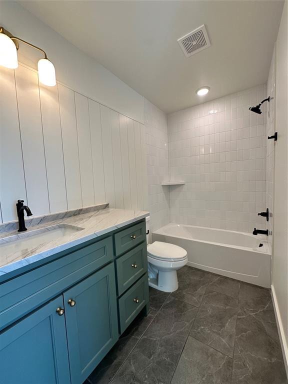 full bathroom featuring tiled shower / bath combo, vanity, and toilet