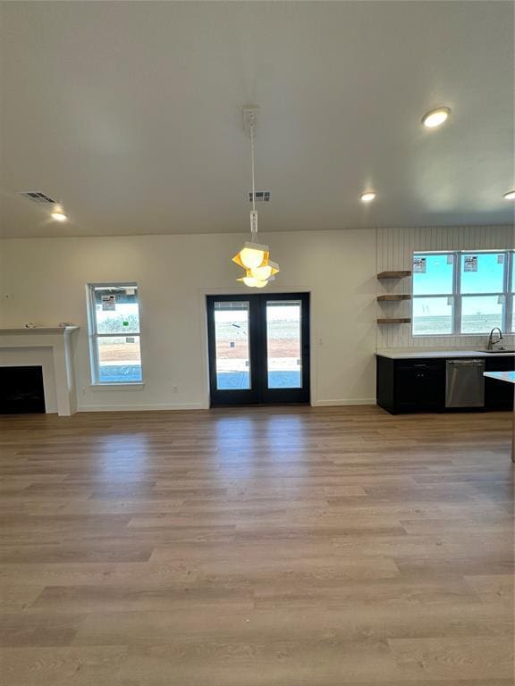 unfurnished living room featuring light hardwood / wood-style floors, a healthy amount of sunlight, and sink