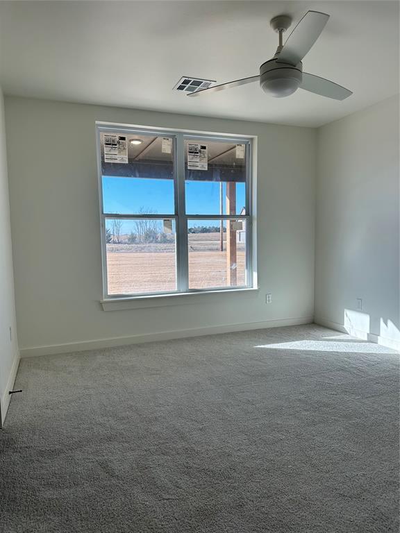 carpeted empty room featuring ceiling fan