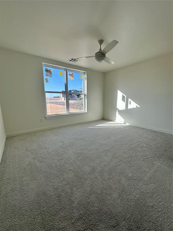 spare room featuring carpet floors and ceiling fan