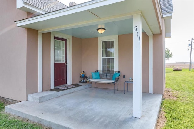 property entrance with a patio area and a yard