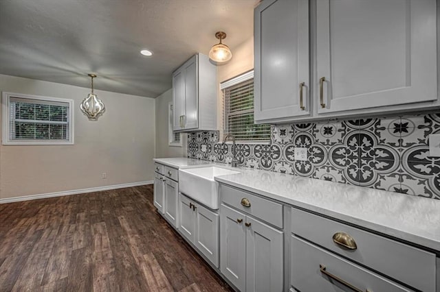 kitchen featuring tasteful backsplash, sink, pendant lighting, gray cabinets, and dark hardwood / wood-style floors