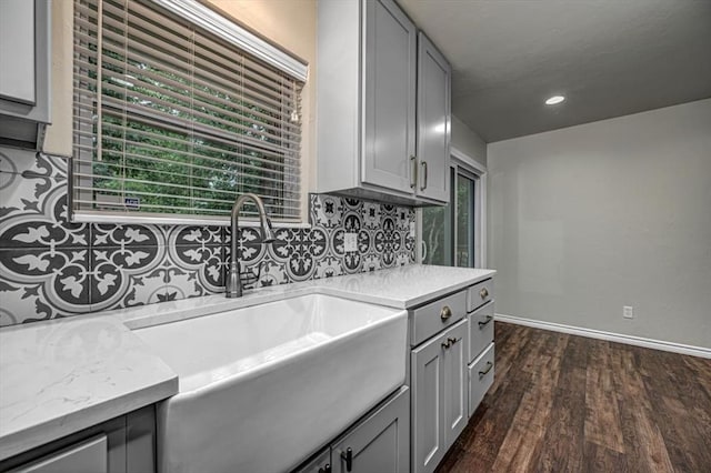 kitchen with decorative backsplash, dark hardwood / wood-style flooring, plenty of natural light, and gray cabinetry