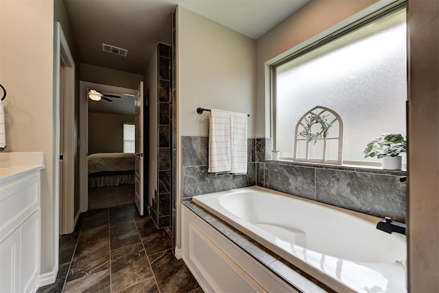 bathroom featuring a washtub, ceiling fan, and vanity