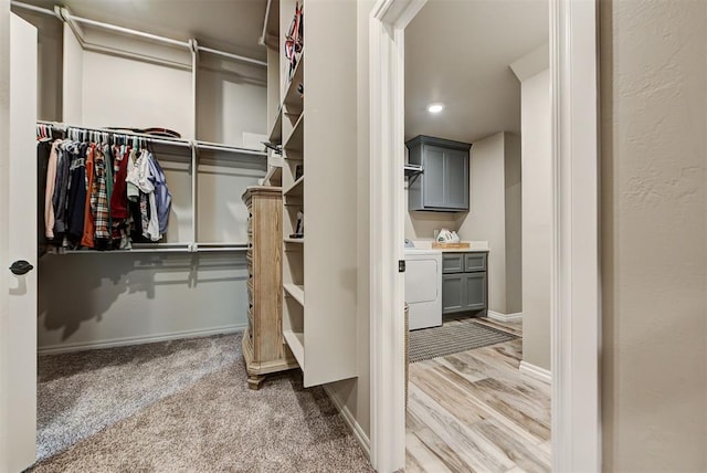 spacious closet with washer / dryer and light wood-type flooring