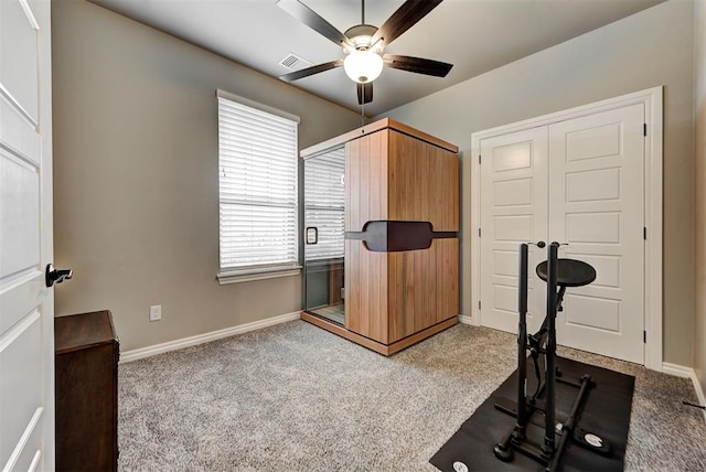 workout area with light colored carpet and ceiling fan