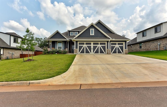 craftsman inspired home with a garage and a front lawn