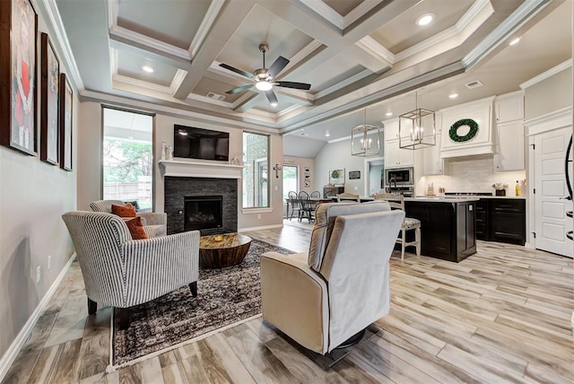 living room featuring light wood-type flooring, ornamental molding, a fireplace, and a wealth of natural light