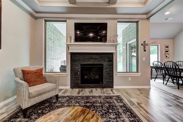 living room featuring a fireplace, hardwood / wood-style floors, and ornamental molding