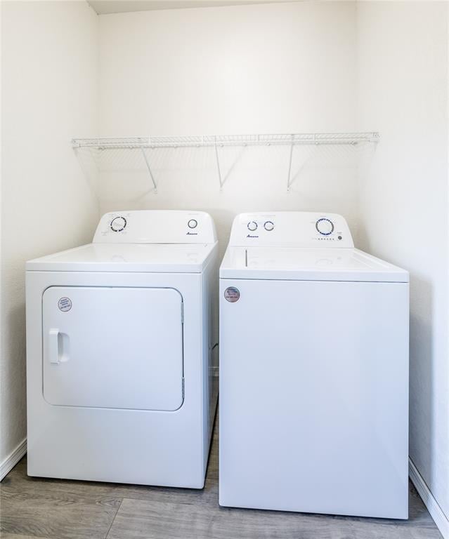 washroom featuring hardwood / wood-style floors and washing machine and dryer