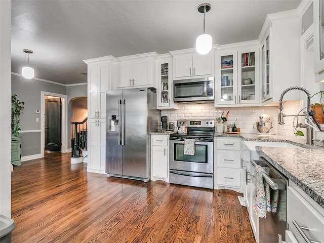 kitchen with dark wood-type flooring, sink, stainless steel appliances, and decorative light fixtures