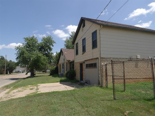 view of side of property featuring central AC and a yard