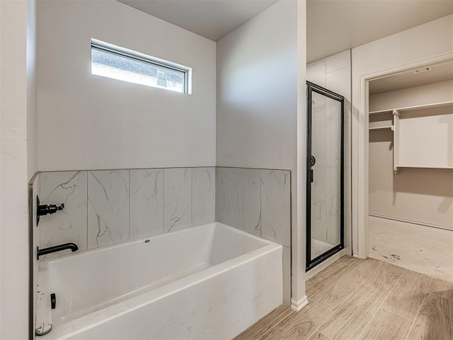 bathroom with hardwood / wood-style floors and independent shower and bath