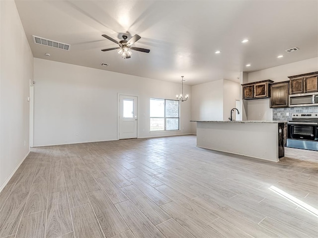 unfurnished living room with light hardwood / wood-style flooring, ceiling fan with notable chandelier, and sink