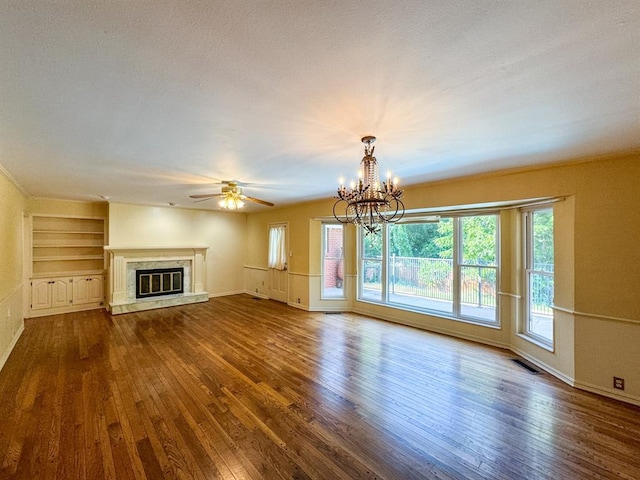 unfurnished living room featuring ceiling fan with notable chandelier, wood-type flooring, and a fireplace