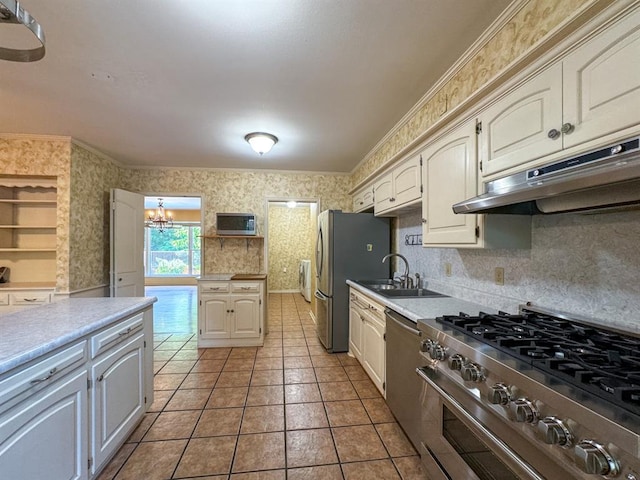 kitchen with sink, stainless steel appliances, tile patterned floors, a chandelier, and ornamental molding